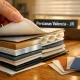 Primer plano de un libro de muestras de persianas en una mesa de roble, mostrando variedad de texturas y colores. Que empresa ofrece mayor variedad de persianas en Valencia.